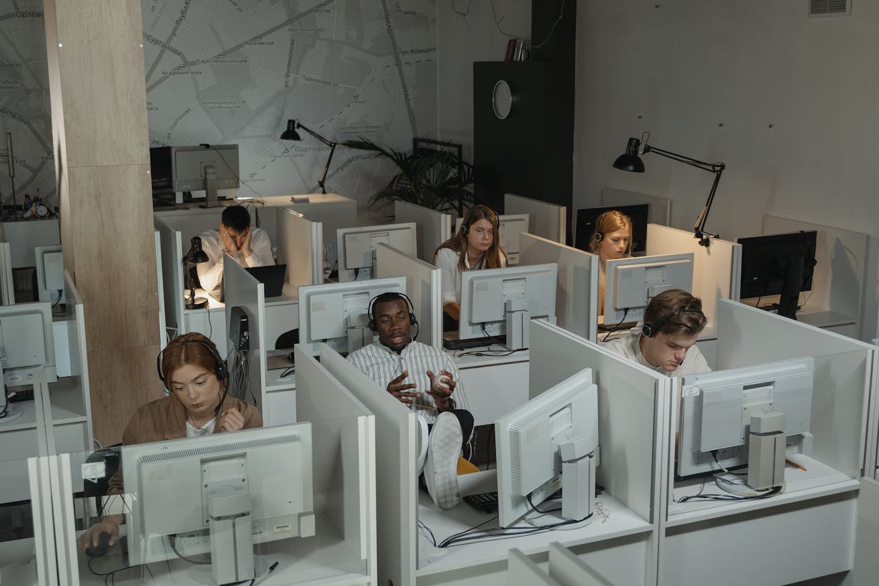 Call center with diverse employees working at computers, engaged in customer support.